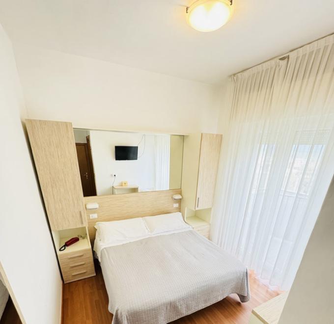 Cozy room with double bed, warm tones, and soft lighting.