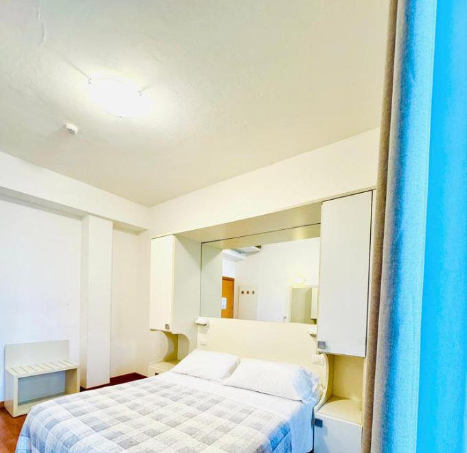 Bright room, cozy bed, serene and relaxing atmosphere.