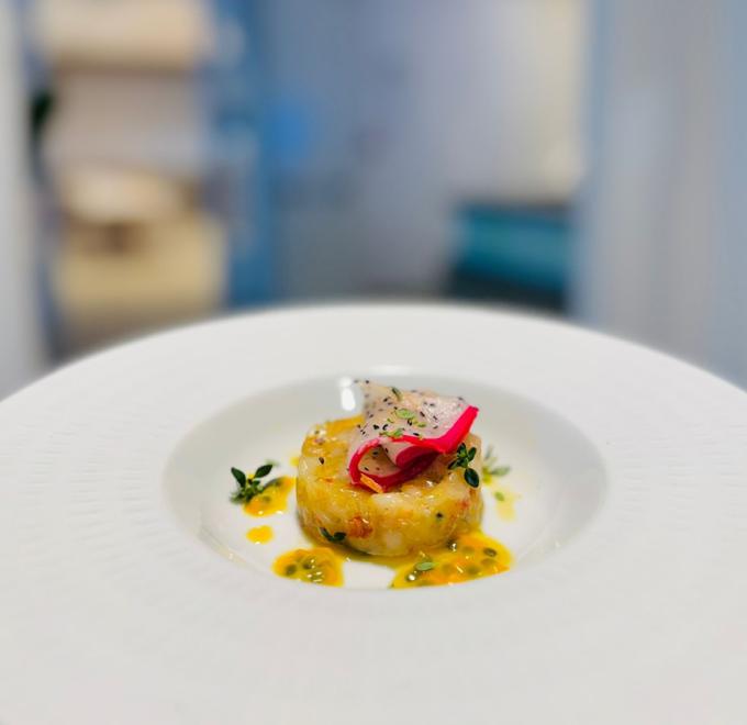 Elegant dish with colorful tartare, garnished with herbs and vibrant sauce.