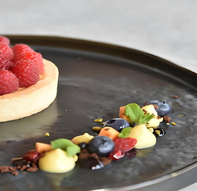 Raspberry tart with colorful garnishes, fresh and inviting on an elegant plate.